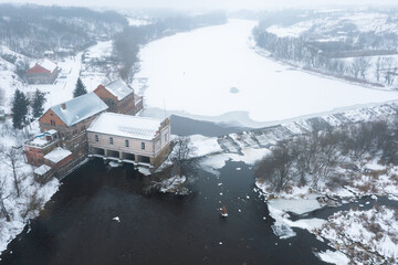 Old hydroelectric power station. small power plant from a great height, in winter. Aerial view of the hydroelectric plant in winter. Dam on the river