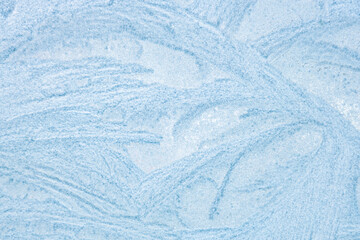 Ice patterns froze on the window. Clean blue background. beautiful texture of nature.