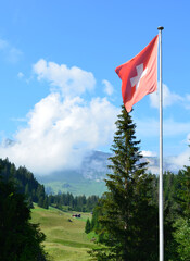 Swiss flag in cloud covered mountains