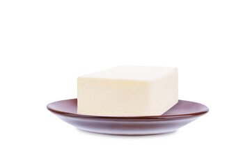 Fresh butter briquette in a brown plate on a white isolated background