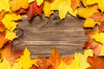 Autumn mood composition background. Frame made of autumn dried leaves on wooden background....