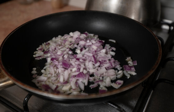 Black Metal Pan Filled With Chopped Onions Frying On The Hot Burner