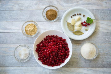 The process of making redcurrant sauce. Currant berries and spices are prepared in glass bowls.