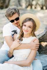 Man hugging woman in straw hat