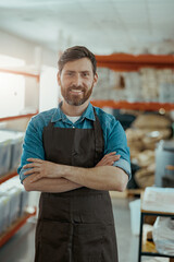 Smiling business owner standing on the background of own coffee roasting factory