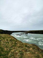 Vertical river water flow wild nature iceland grey clouds roadtrip
