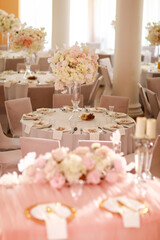 festive wedding decoration. Beautiful fresh white and pink flowers in glass vase on dining table on wedding day. High quality photo