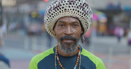 Black man wearing big hat serious face portrait on a street