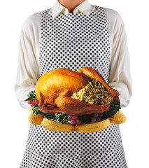 Thanksgiving: Closeup of a homemaker in an apron and oven mitts holding a platter with a roasted turkey.  Woman is unrecognizable. Shallow depth of field with transparent backghround