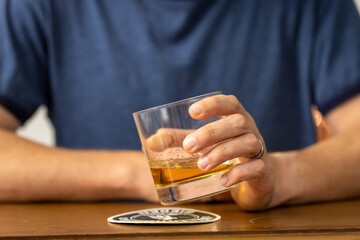 Man Swirling Glass of Whiskey at a Bar