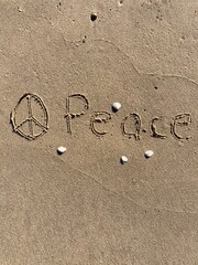 Fototapeta na wymiar on the beach is carved with letters in the smooth sand the writing Peace