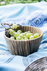 Wicker basket full of green grapes. Picnic