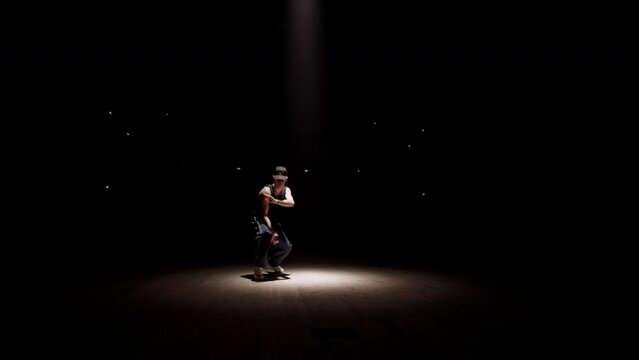 young jazz-funk dancer is dancing on scene, moving in soffit ray, professional break dancer man