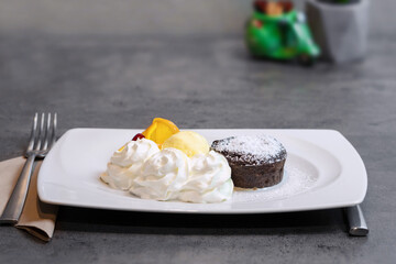 Chocolate Souffle with whipped cream and sliced orange, fondant chocolate cake