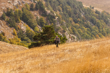 Fototapeta na wymiar A tourist walks along the slope of the Demerdzhi mountain range