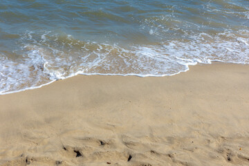 Selective focus of white sand beach with the wave approaching, The bubble of the sea shore, Nature texture background.