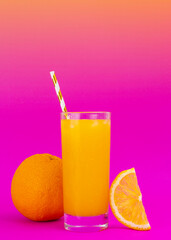 A glass of orange juice on fade pink background, vertical