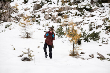 Mid Adult Woman Hiker Carefully Descending a Hill in a Cold Winter Idyllic Mountains Environment...