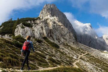 Naklejka na ściany i meble Woman Backpack Hiker Moving Up on a Beautiful Alpine Footpath