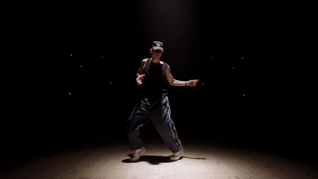 street dancer is performing trendy dance styles in rehearsal room, popping, locking and hip hop
