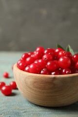 Tasty ripe cranberries on light blue wooden table, closeup