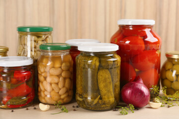 Jars of pickled vegetables on wooden table