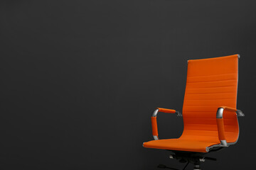 Comfortable office chair on black background. Space for text