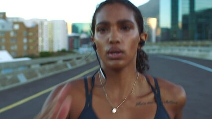 Running, music and fitness with a woman athlete training on a run for health, wellness and exercise. Sport, healthy and motivation with a young female runner exercising and working out in the city