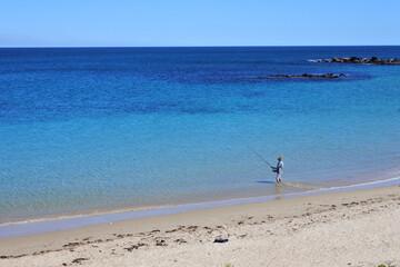 Fototapeta na wymiar Australian man fishing on a remote beach