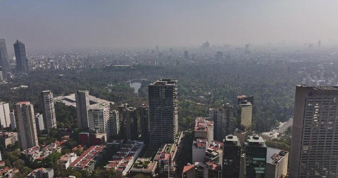 Mexico City Aerial v89 panoramic view drone fly around prestigious polanco neighborhood capturing bosque de chapultepec park and urban cityscape with foggy sky - Shot with Mavic 3 Cine - January 2022