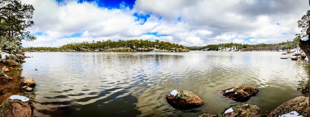 winter landscape in a lake with forest and pine trees with snow and blue sky with clouds in arareco lake in creel chihuahua 