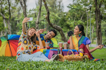 LGBTQ people friends enjoying picnic together in park and having selfie