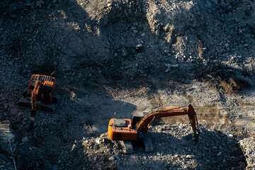 Hydraulic crusher excavator backoe machinery working in the rain on site demolition. Destruction of...