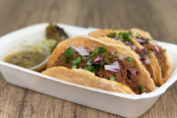 Loaded slow cooked birria meat tacos topped with onions and served with a grilled jalapeno, salsa,...