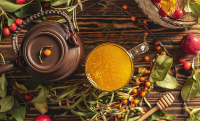 Autumn vitamin sea buckthorn tea made from fresh berries on a wooden table. Top view