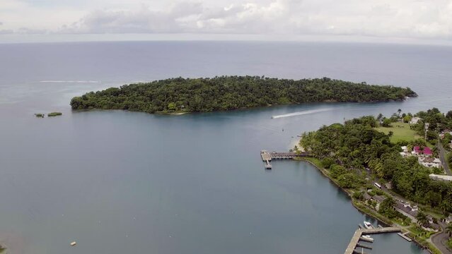 Aerial view of Navy Island in Port Antonio in Jamaica whilst a speedboat sails through the channel between the harbour and island