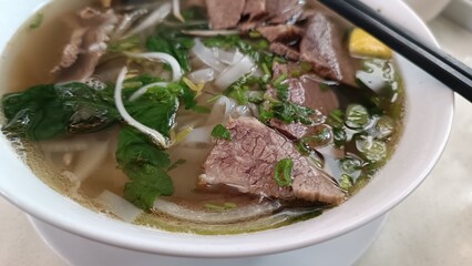 Vietnam food pho soup in a white bowl and chopstick