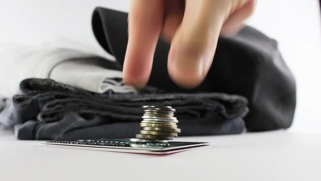 Coins and clothes on a white background.The concept of the cost,price of clothes.Purchase, rise in price of clothes.