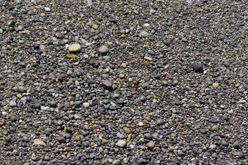 Wet and water covered pebbles on an ocean beach