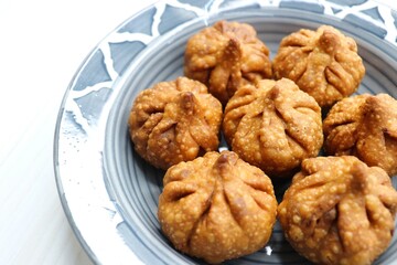 Fried Modak. It's a traditional sweet dish of coconut, jaggery, and dry fruits stuffed inside the wheat dough. Offered to Lord Ganesha during the Ganpati Chaturthi festival in India. with copy space. 