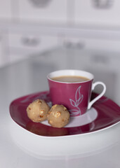 Marzipan made from almond flour and sweetener. A healthy low-carb and high-fat keto dessert. Alternative sweets and a mug of coffee on a white table.