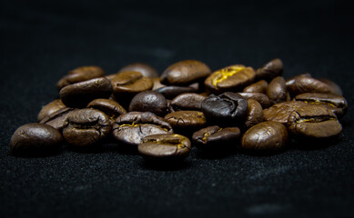 The way coffee beans lay on a black background, elegant and delicious coffee beans and the aroma of morning coffee.