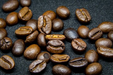 The way coffee beans lay on a black background, elegant and delicious coffee beans and the aroma of morning coffee.