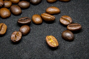 The way coffee beans lay on a black background, elegant and delicious coffee beans and the aroma of morning coffee.