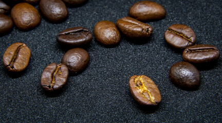 The way coffee beans lay on a black background, elegant and delicious coffee beans and the aroma of morning coffee.