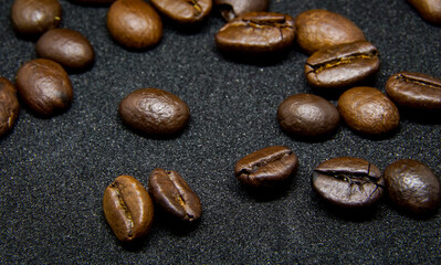 The way coffee beans lay on a black background, elegant and delicious coffee beans and the aroma of morning coffee.