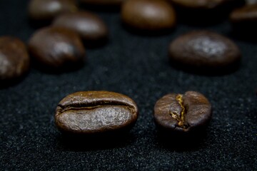The way coffee beans lay on a black background, elegant and delicious coffee beans and the aroma of morning coffee.