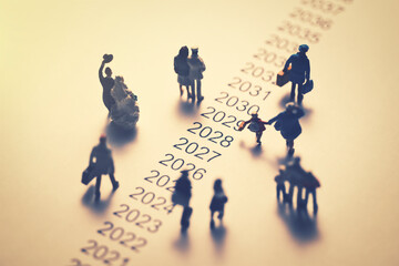 年表の横を歩くミニチュアの人々