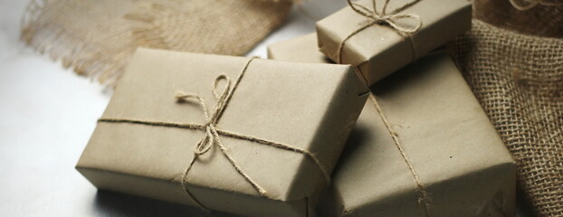 Gift box wrapped in brown recycled paper placed on a white table