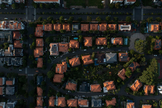 Top down aerial view of upmarket housing estate in beautiful dramatic afternoon light with streets, trees and public areas.